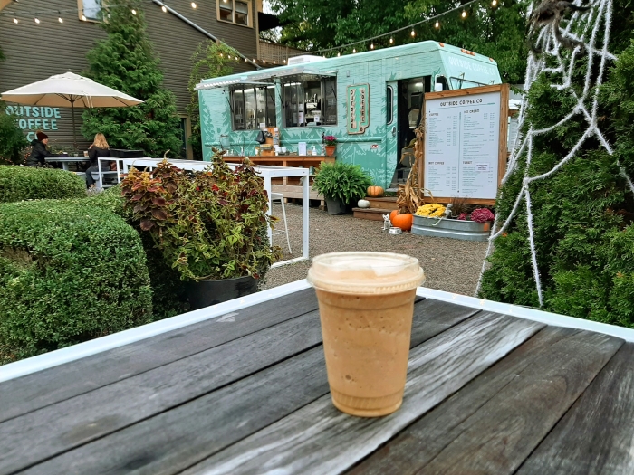 Picnic table in garden by Outside Coffee Co. trailer