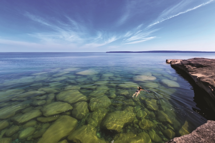 Woman swimming in water at Paradise Cove on Lake Superior.