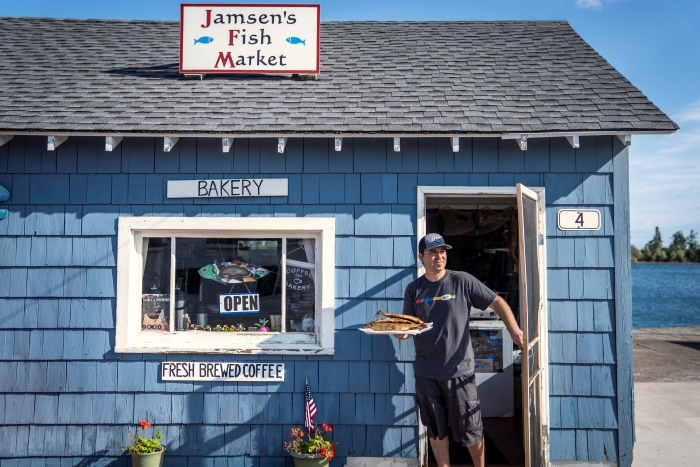 Man walking out of Jamsen's Fish Market with smoked fish.